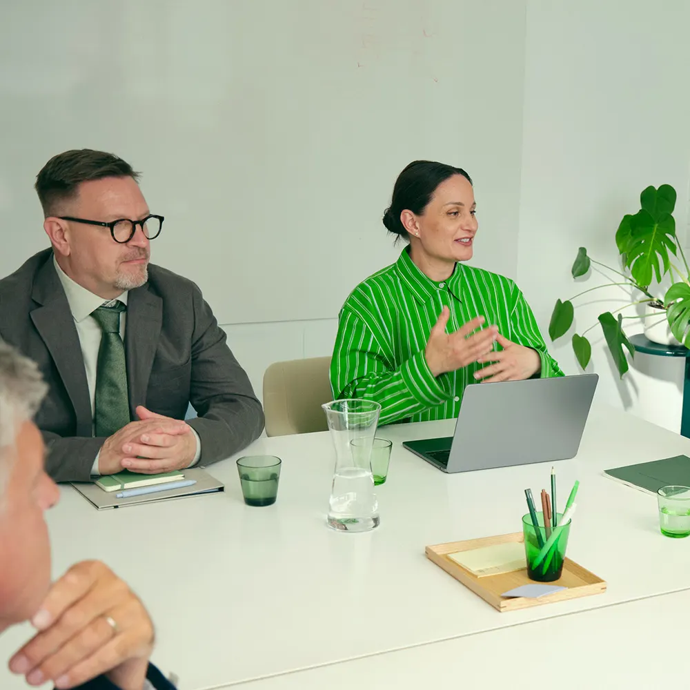 Människor som sitter runt ett konferensbord.