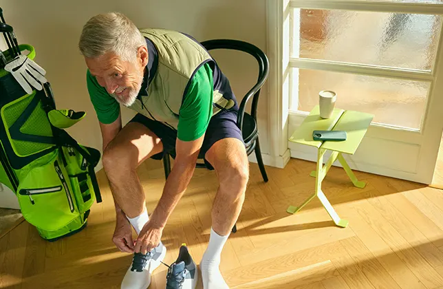 En man tar på sig sina skor.