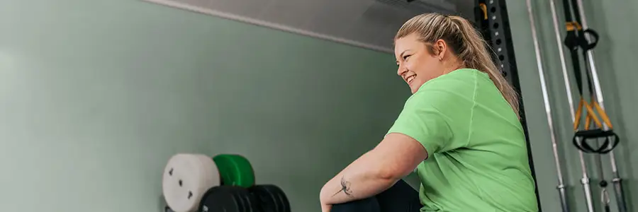 En kvinna stretchar på gymmet.