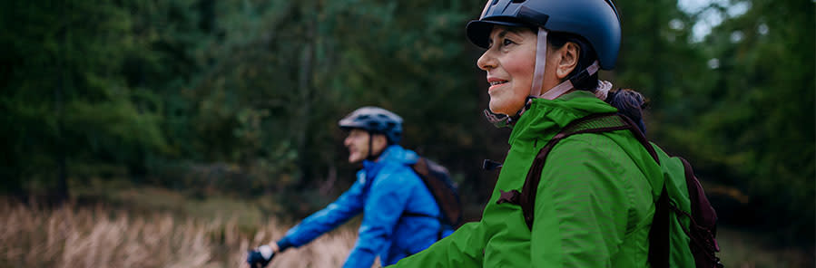 En man och en kvinna cyklar i skogen.