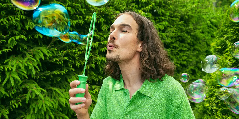Mies puhaltaa saippuakuplia.