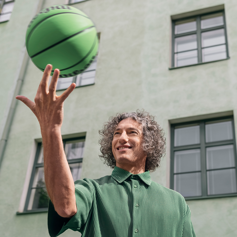 En man snurrar en basketboll med sitt finger.