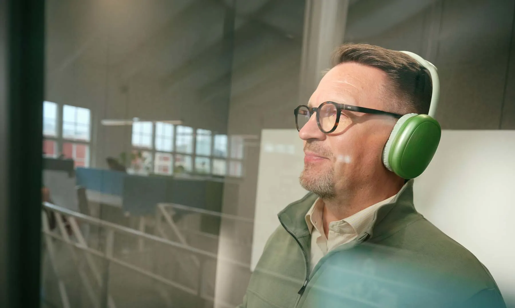 Mies kuuntelee kuulokkeilla.