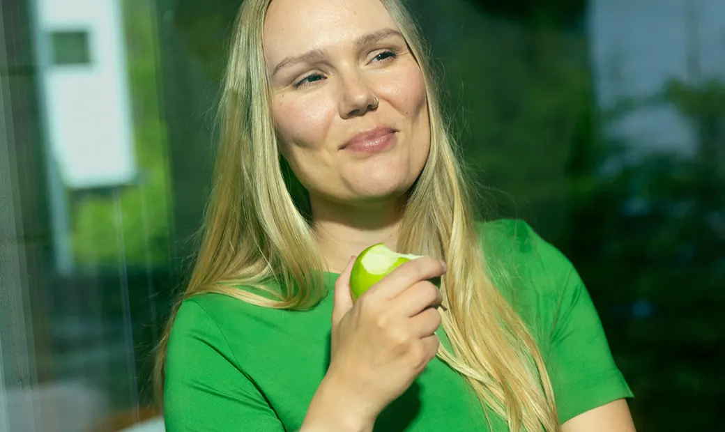 En kvinna med ett äpple i handen.