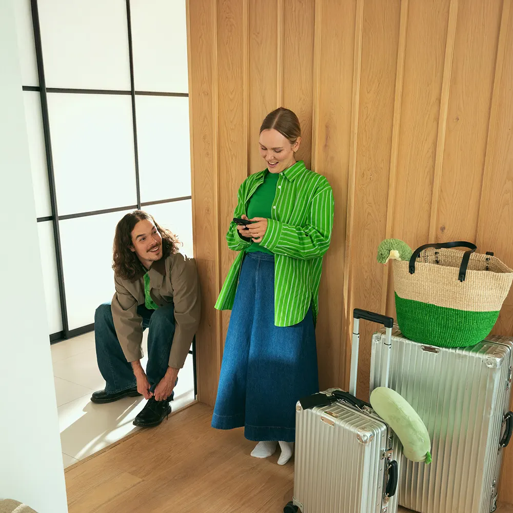 En kvinna och en man i korridoren med sina resväskor.