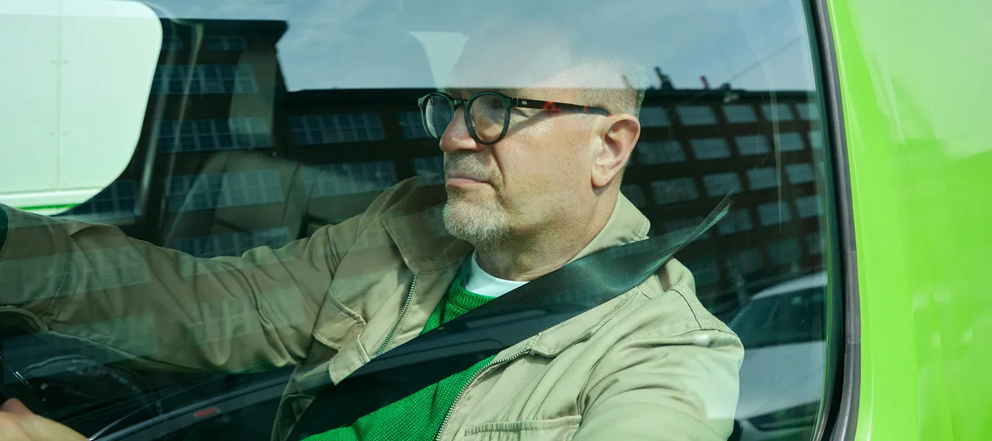 Mies istuu autossa.