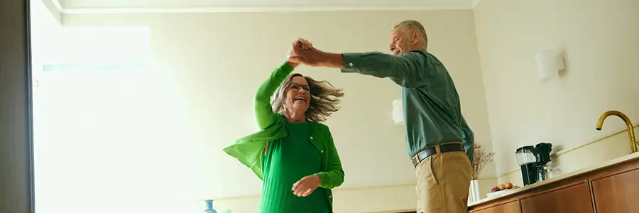 En kvinna och en man dansar i ett kök.