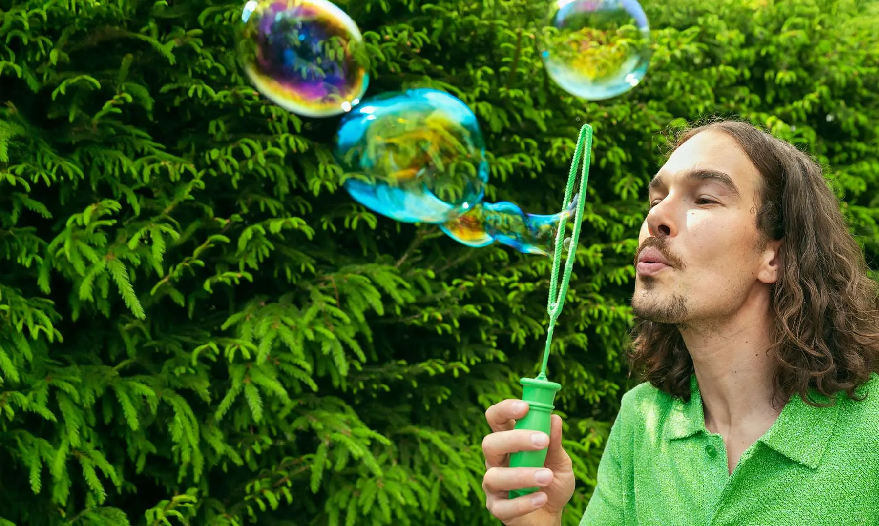 Mies puhaltaa saippuakuplia.