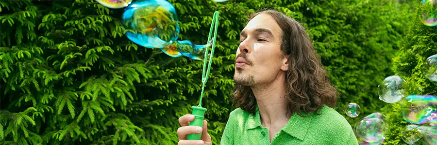 Mies puhaltaa saippuakuplia.
