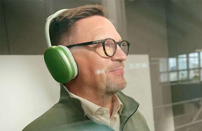 Mies kuuntelee kuulokkeilla. 