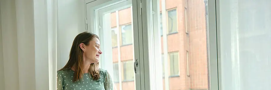 Kvinna framför ett fönster.