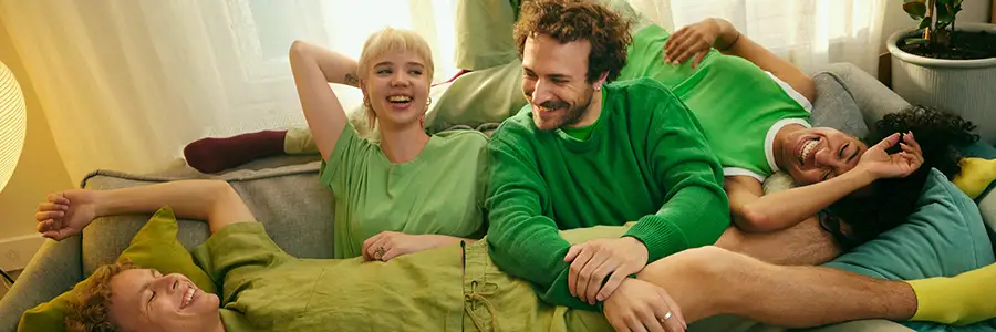 Unga människor sitter på en soffa.