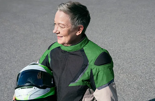 Kvinnan håller i en motorcykelhjälm.