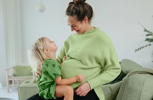 Barnet sitter i kvinnans knä.