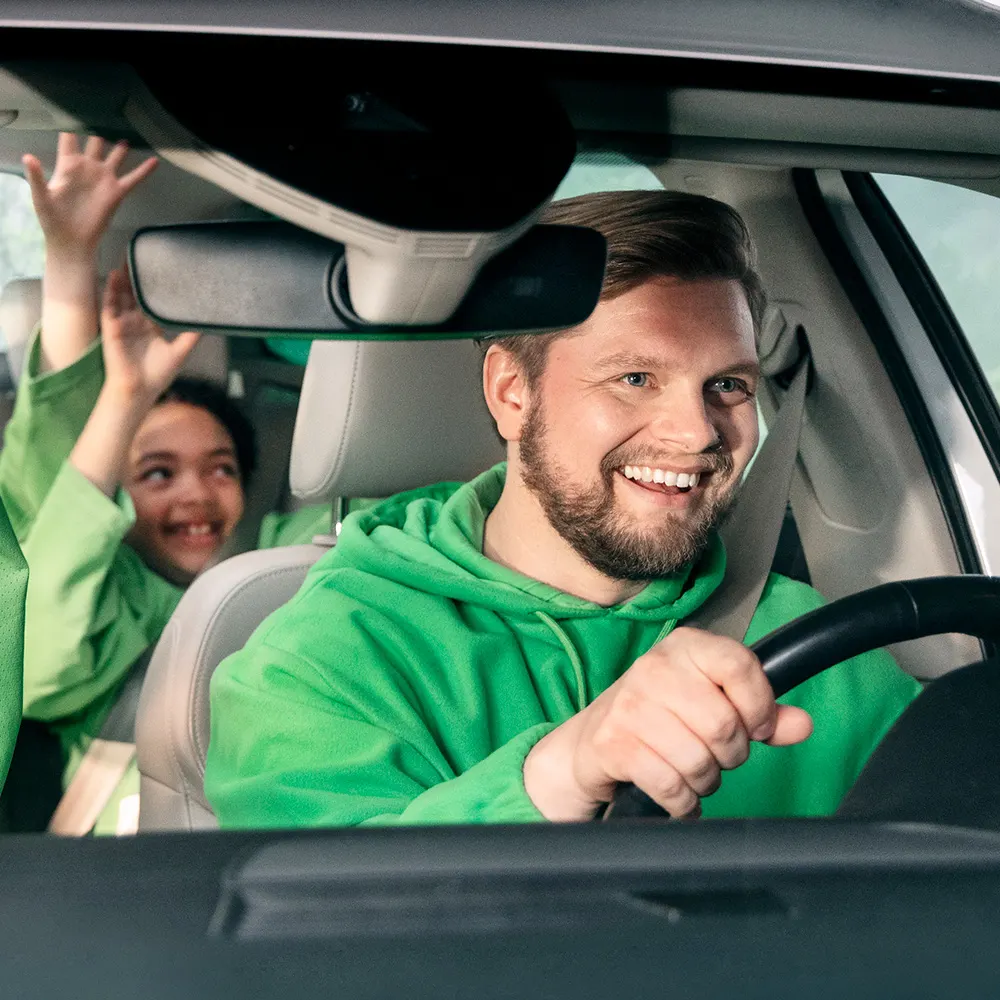 En man kör bil glatt.