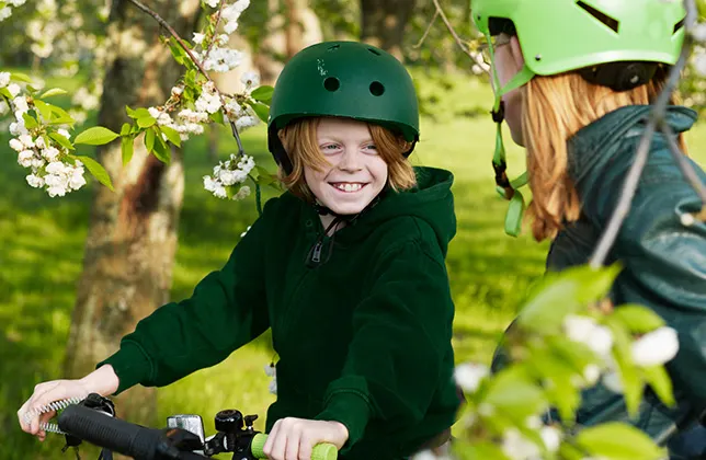 Barnet cyklar med hjälm på huvudet.
