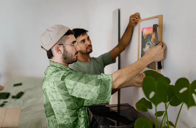 Män som hänger upp en bild på väggen.