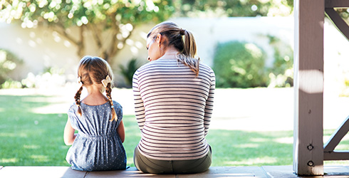 mother and daughter talking on porch