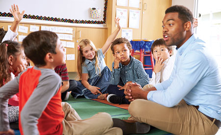 teacher with students sitting on floor