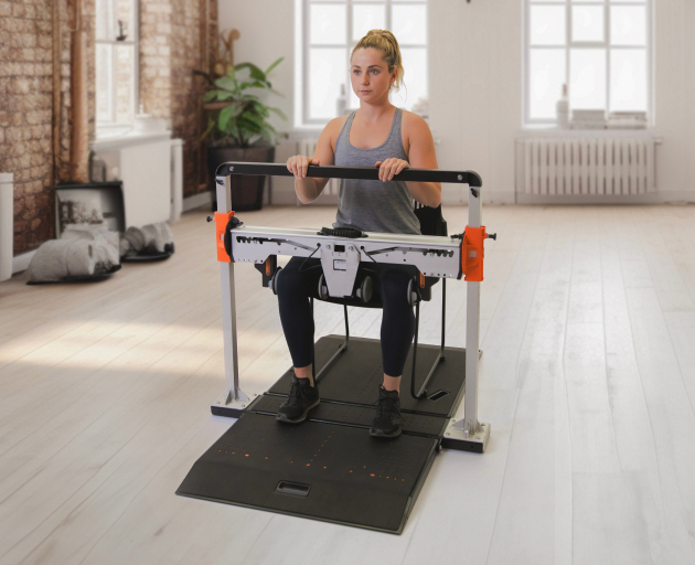 Woman performing seated forceframe hip abductor/adductor test