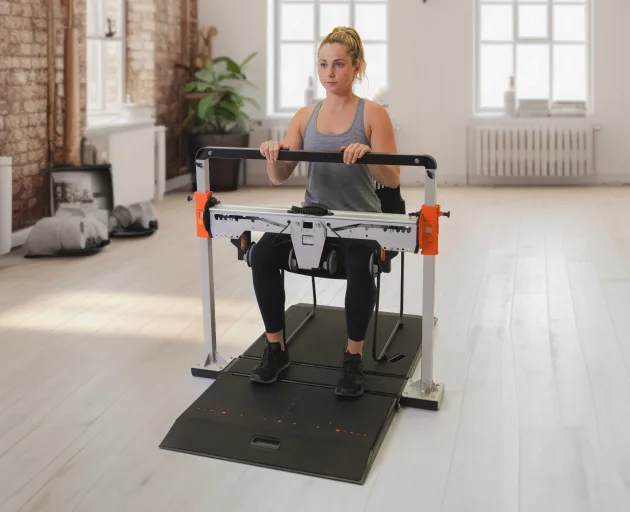 Woman performing seated forceframe hip abductor/adductor test
