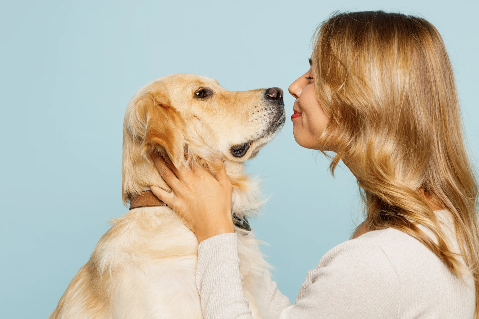 A woman smiling and holding a dog