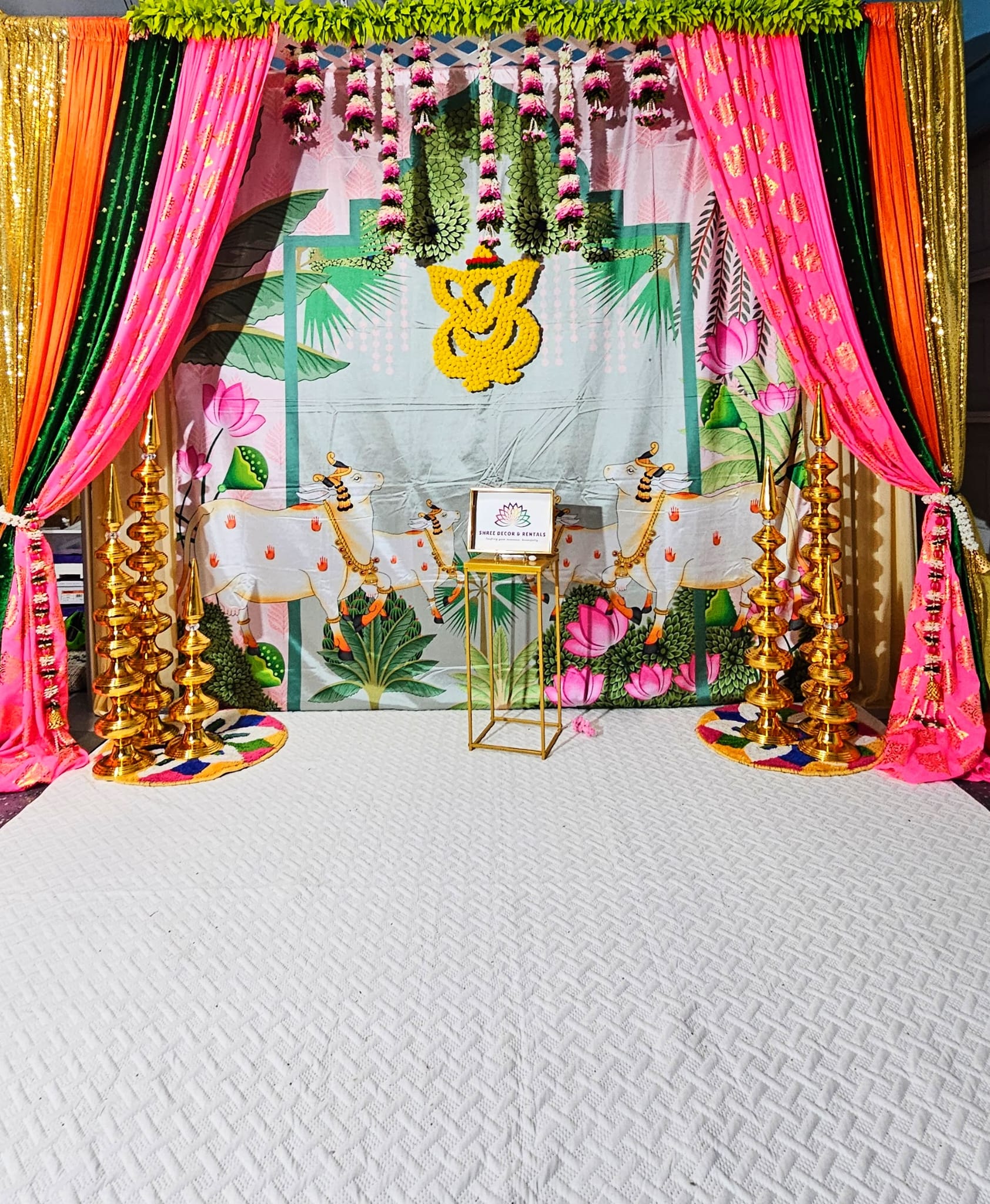 Divine Cow and Ganesha Themed Backdrop with Vibrant Floral Drapes