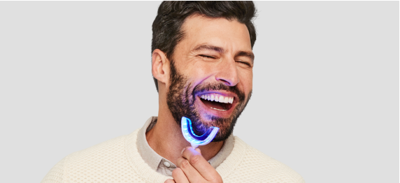 Man smiling holding SmileDirectClub Teeth Whitening LED Light