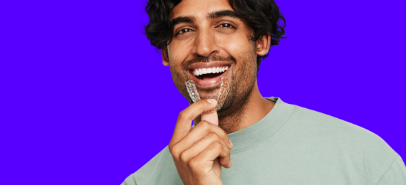 Smiling man holding SDC Aligner in front of his mouth - Cyber Monday Discount Slider - Aligner Tile