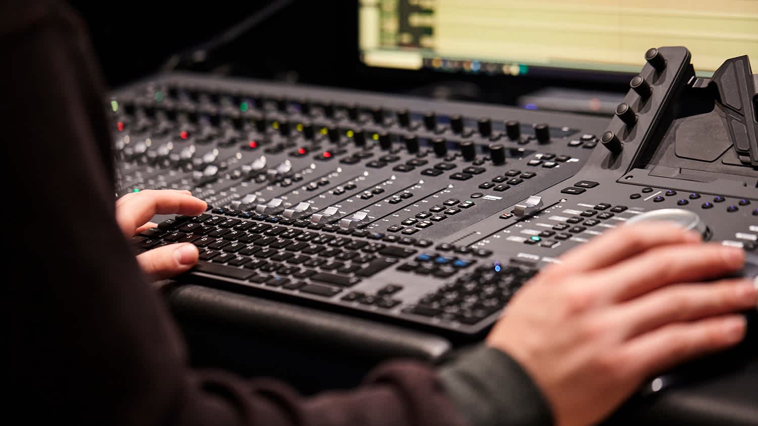 Close up on hands working with an audio console. 