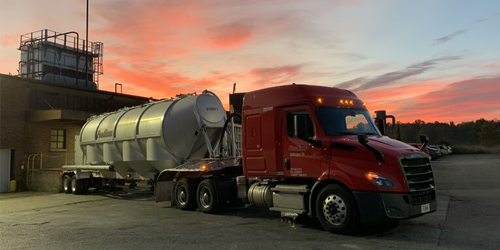Thumbnail image of a mccoy truck backed up to a building.