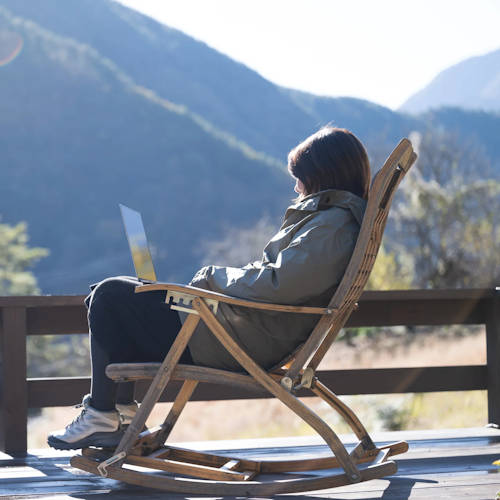 Woman sitting in the chair near the mountains and looking at landscape