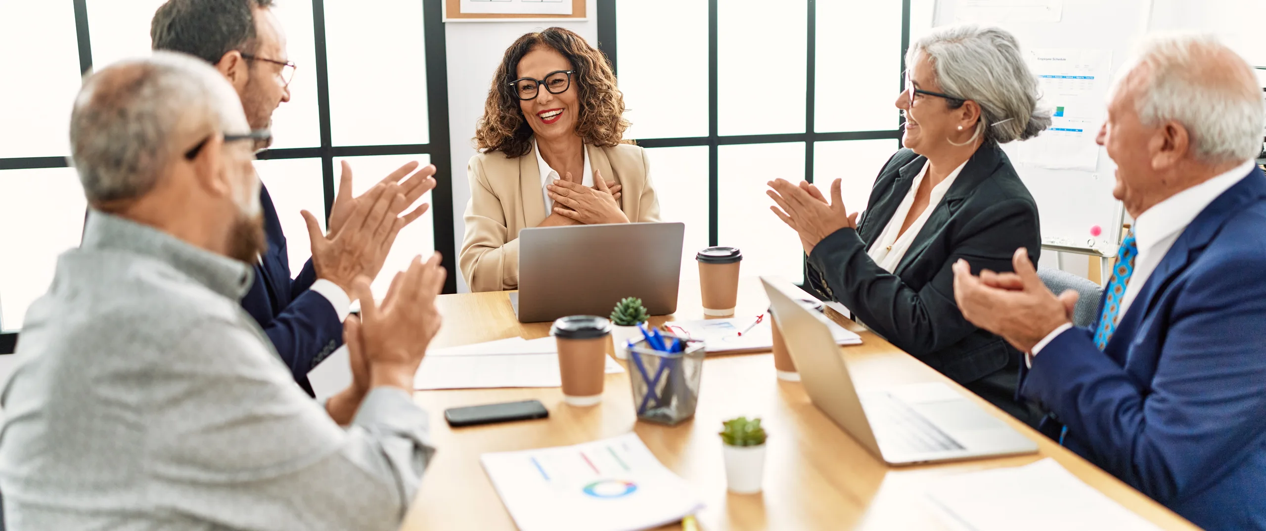 People are applauding at a business meeting