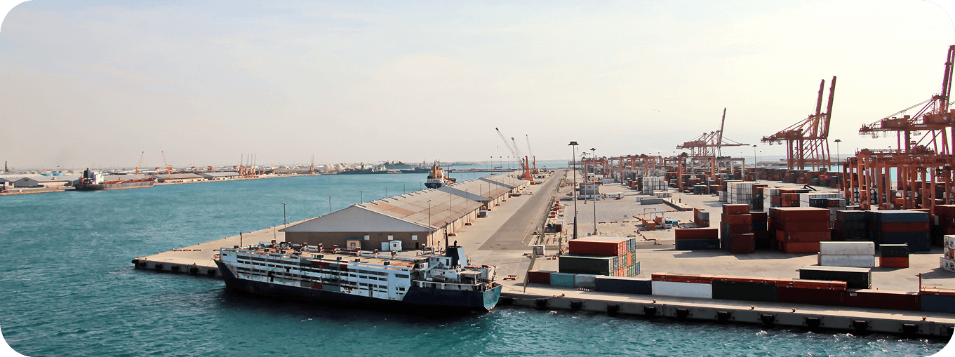 Cargo ships docked at a major Qatari industrial port loading container freight.