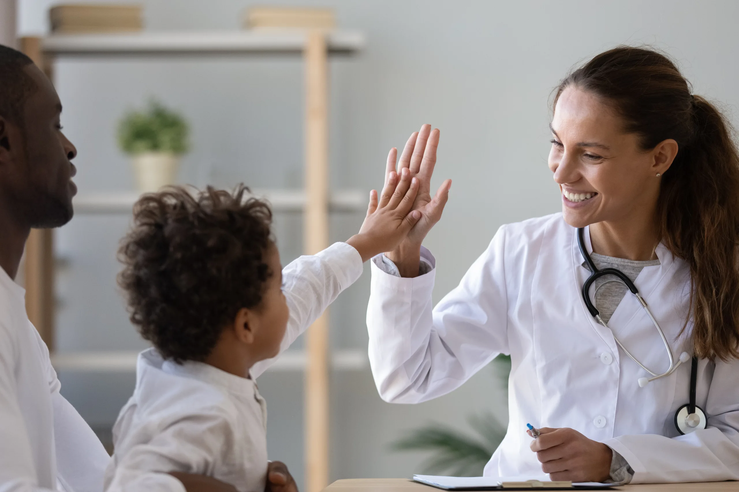 A kid is giving hi-five to the doctor