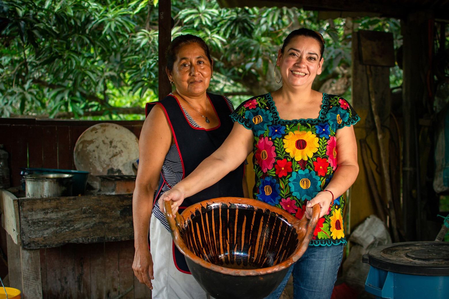 Two women holding a ceramic pot