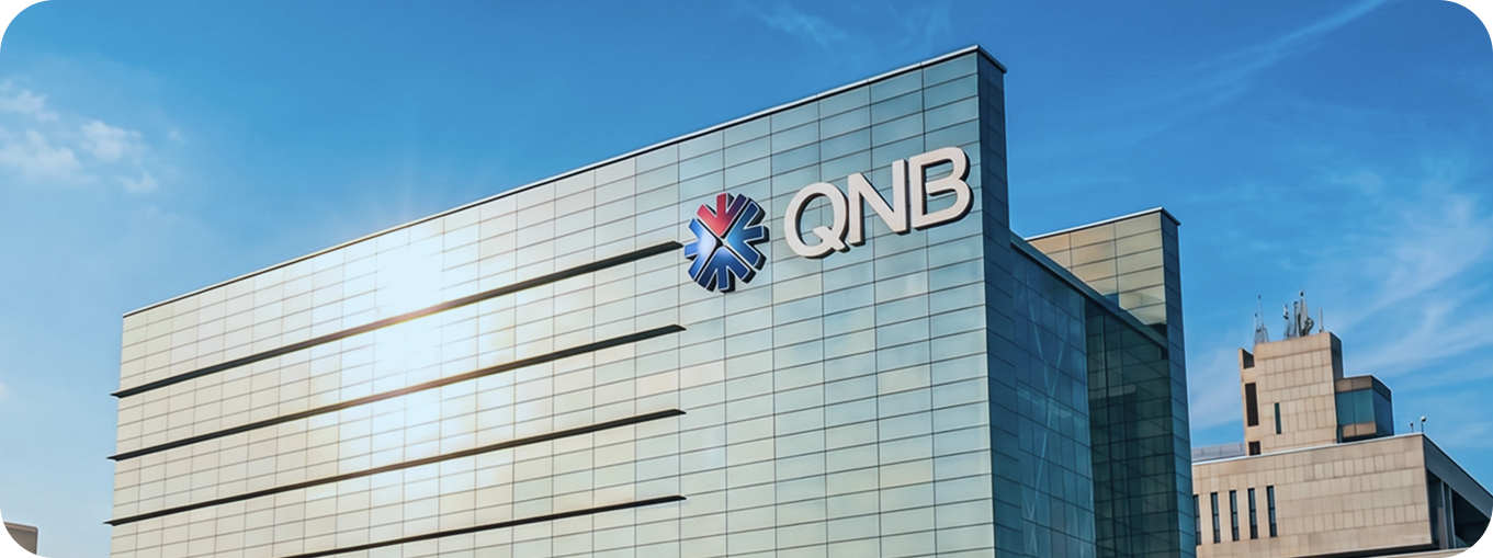 Qatar National Bank (QNB) headquarters building under a clear blue sky.
