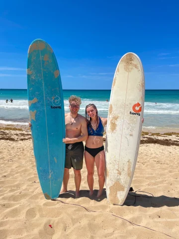 Couple posing with surfing boards