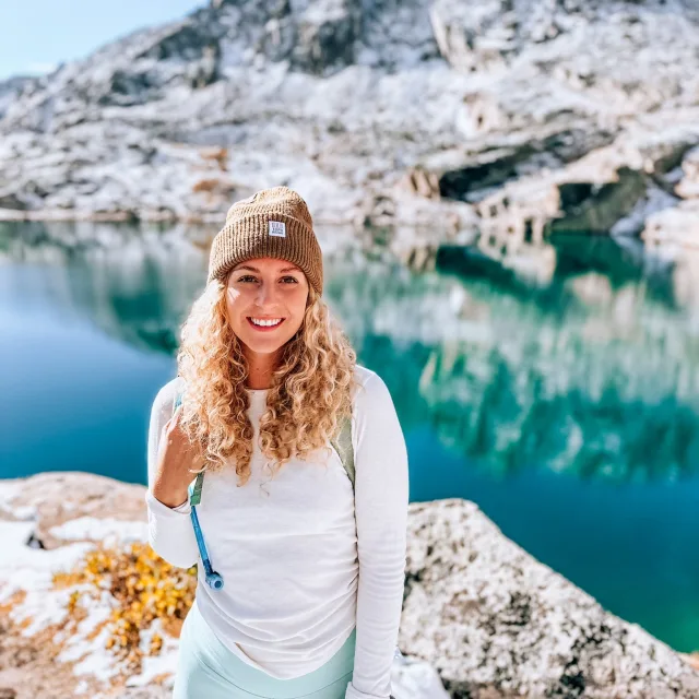 Travel advisor posing in a bennie and white shirt