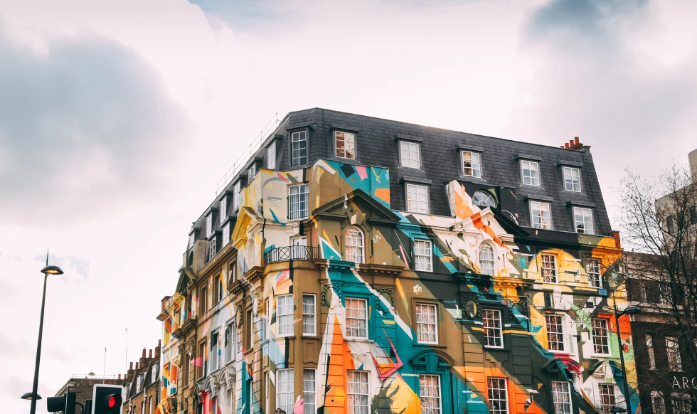 Colorful artwork on the side of a building on a cloudy day