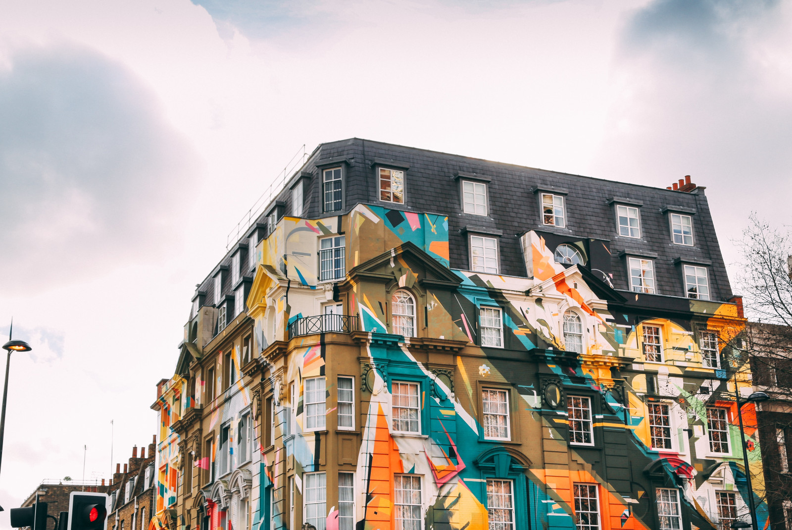 Colorful artwork on the side of a building on a cloudy day