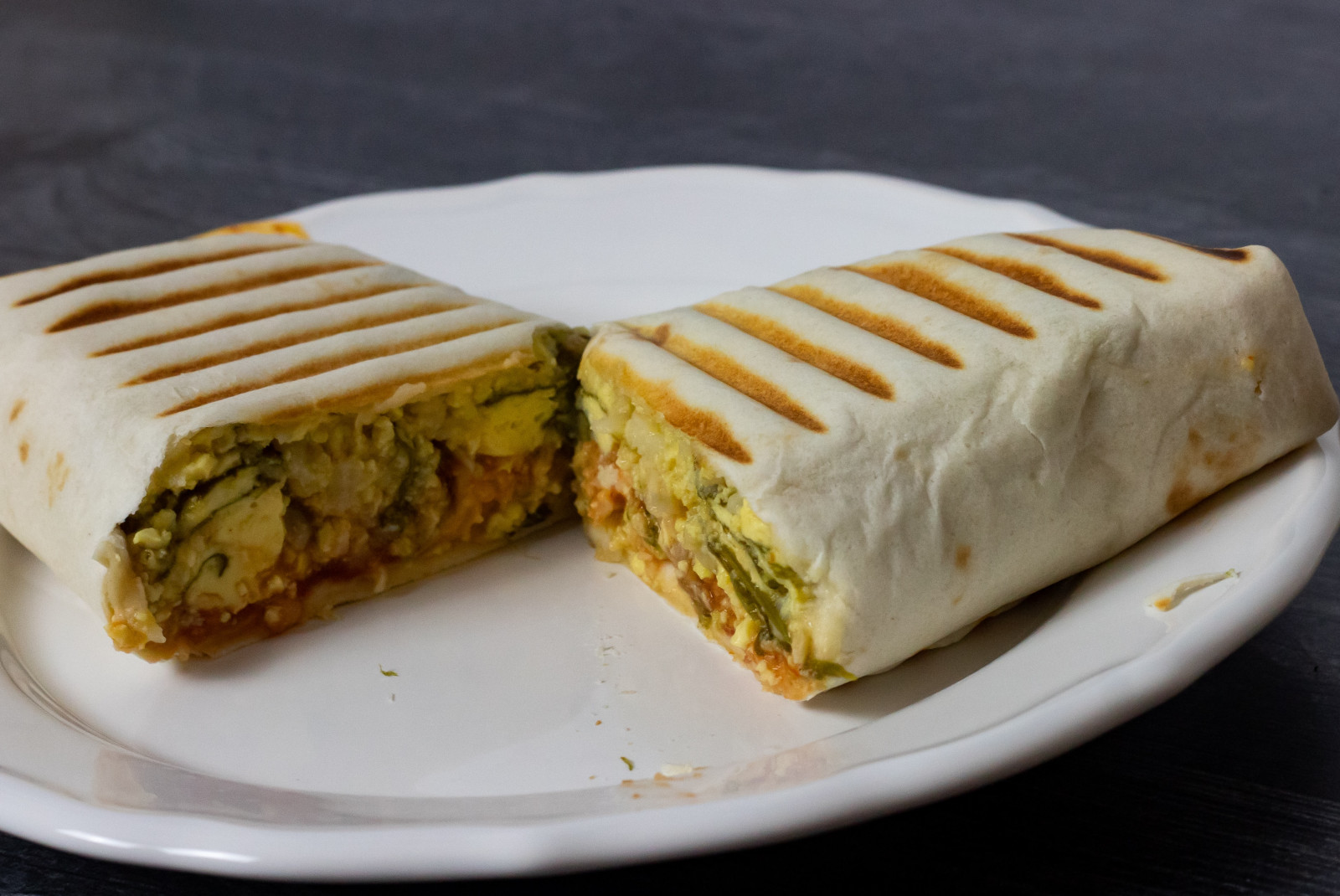 Grilled breakfast burrito on white plate