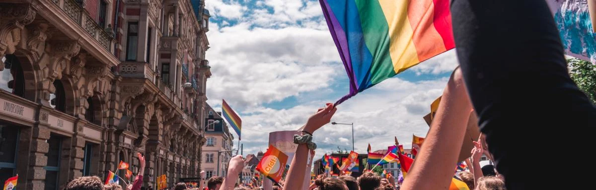 Pride flag waving at LGBTQ+ celebration in city on a sunny day