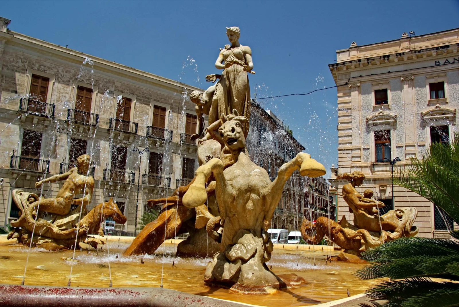 fountain with statures in a city square