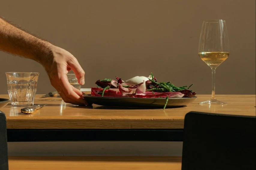 plate of food and a wine glass on a wooden table