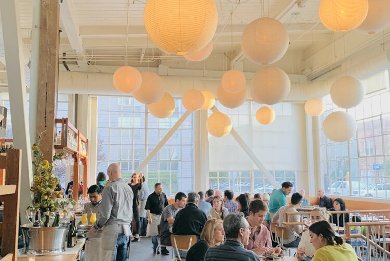 people sitting at tables in a room with orange balloons