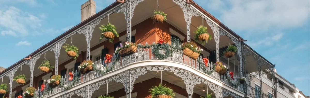 Top of building with balconies decorated with plants in the French Quarter in New Orleans.