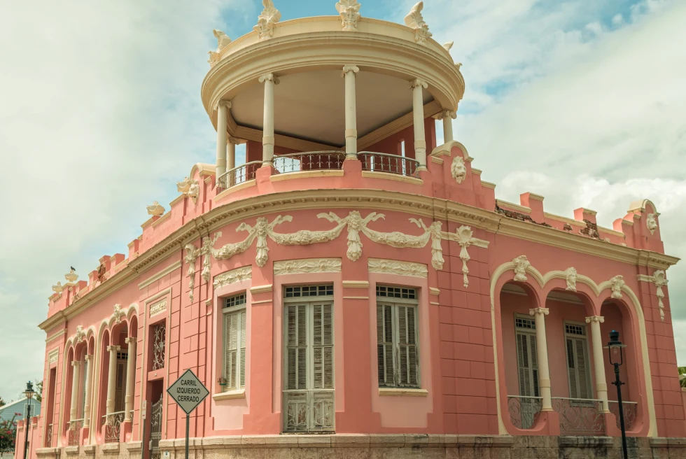 a pink building with a balcony and a balcony
