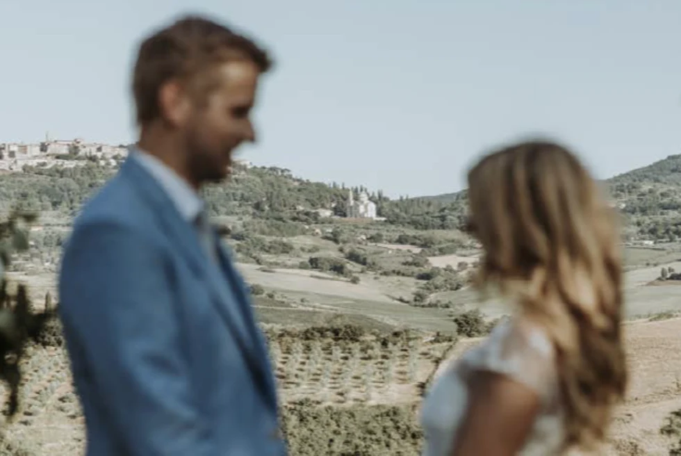Man and woman holding hands with mountainside in the background during daytime