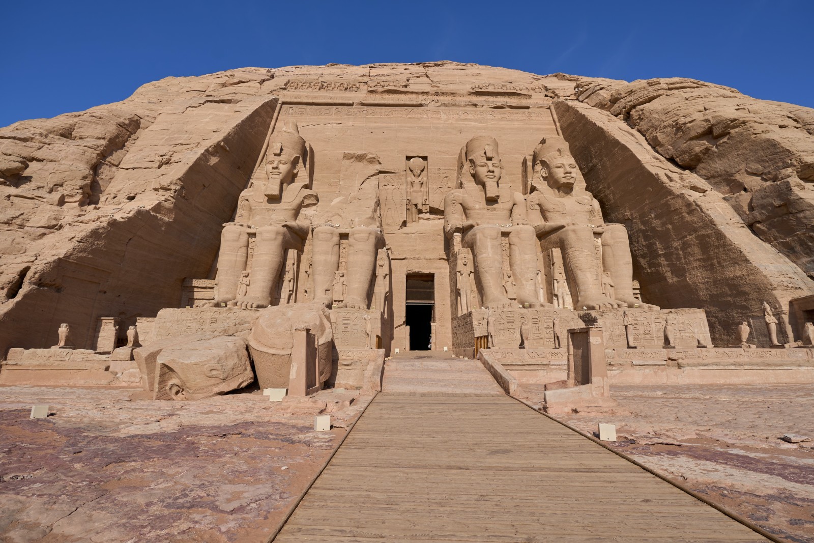 Large carvings in the side of a mountain with blue skies during daytime